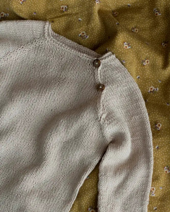 Produktfoto: Emma’s Suit, Strickanleitung für einen Babystrampler in Raglan von oben