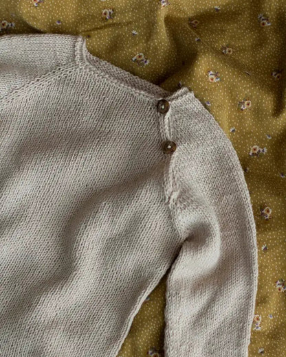 Produktfoto: Emma’s Suit, Strickanleitung für einen Babystrampler in Raglan von oben