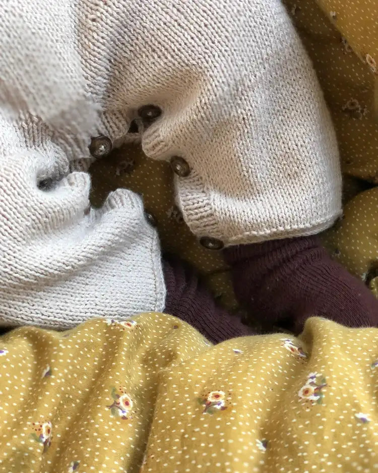 Produktfoto: Emma’s Suit, Strickanleitung für einen Babystrampler in Raglan von oben